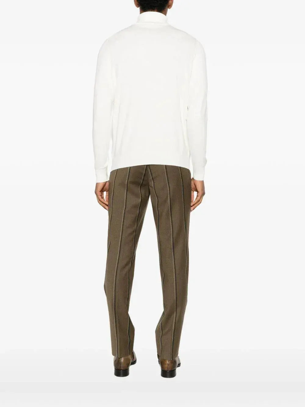 Maglione dolcevita uomo bianco, pantaloni marroni a righe, look elegante di spalle.