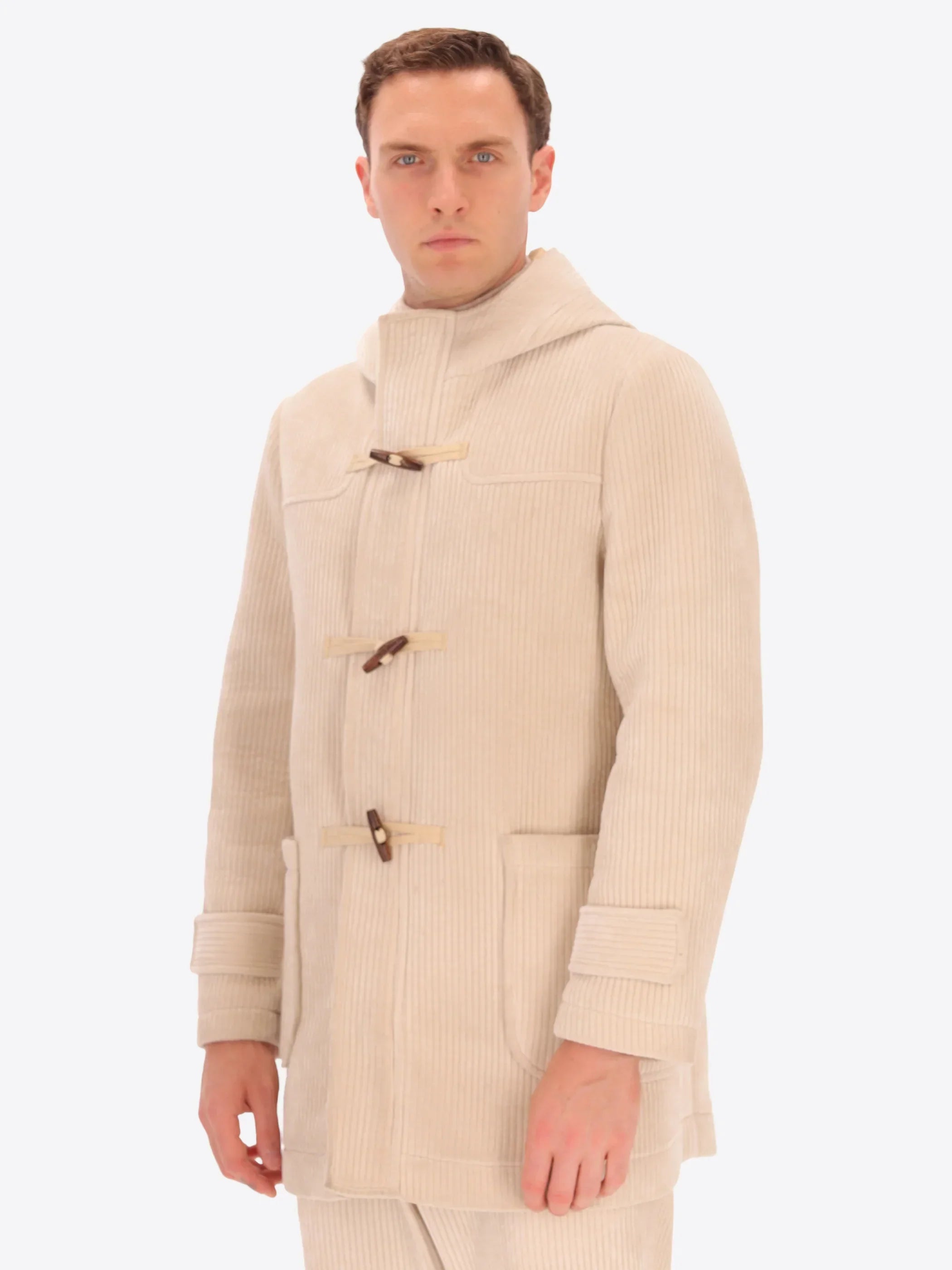 Modello indossa cappotto uomo beige in velluto a coste con alamari, stile elegante.