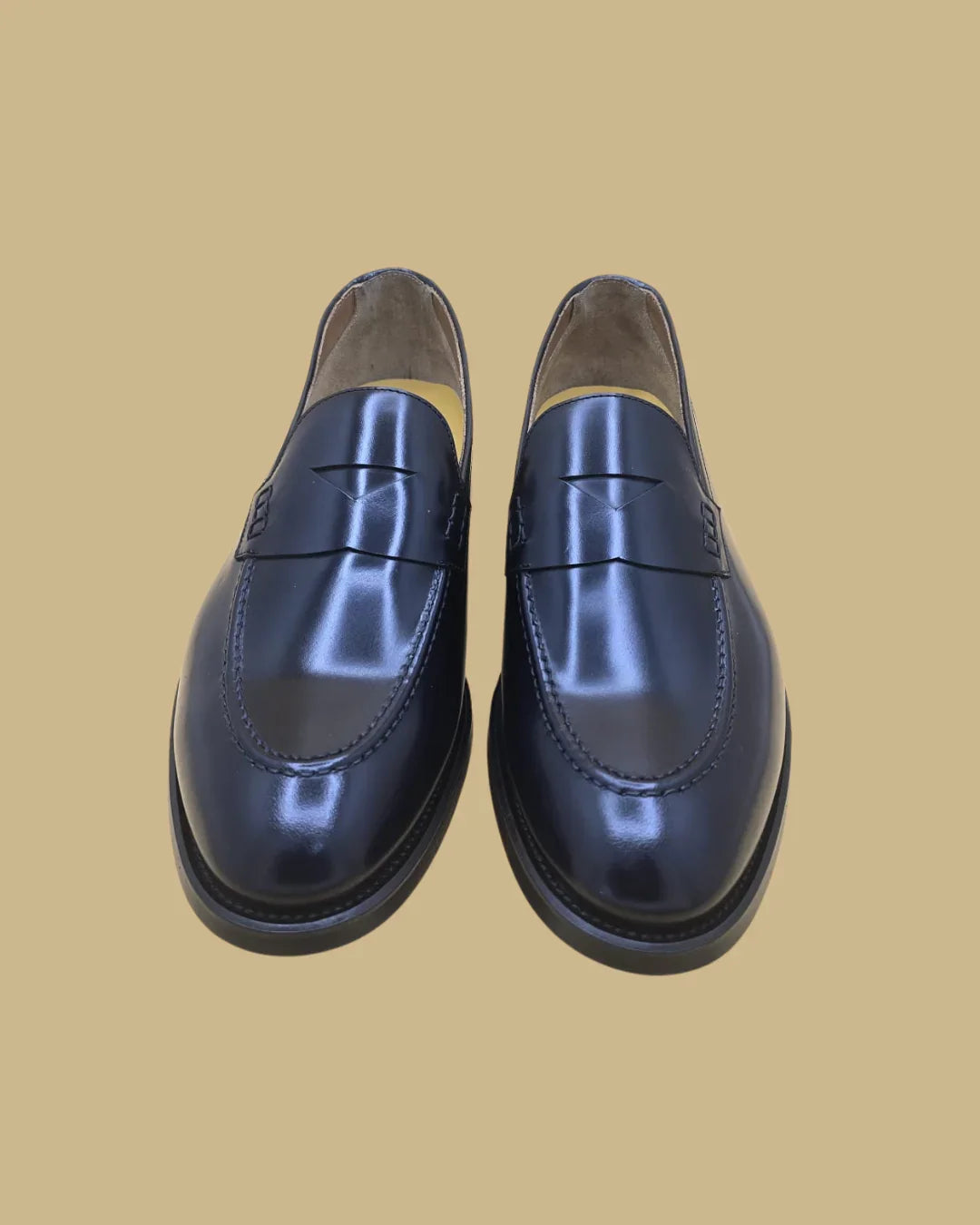 Mocassini penny loafer uomo in pelle blu lucida, eleganti, fondo neutro.