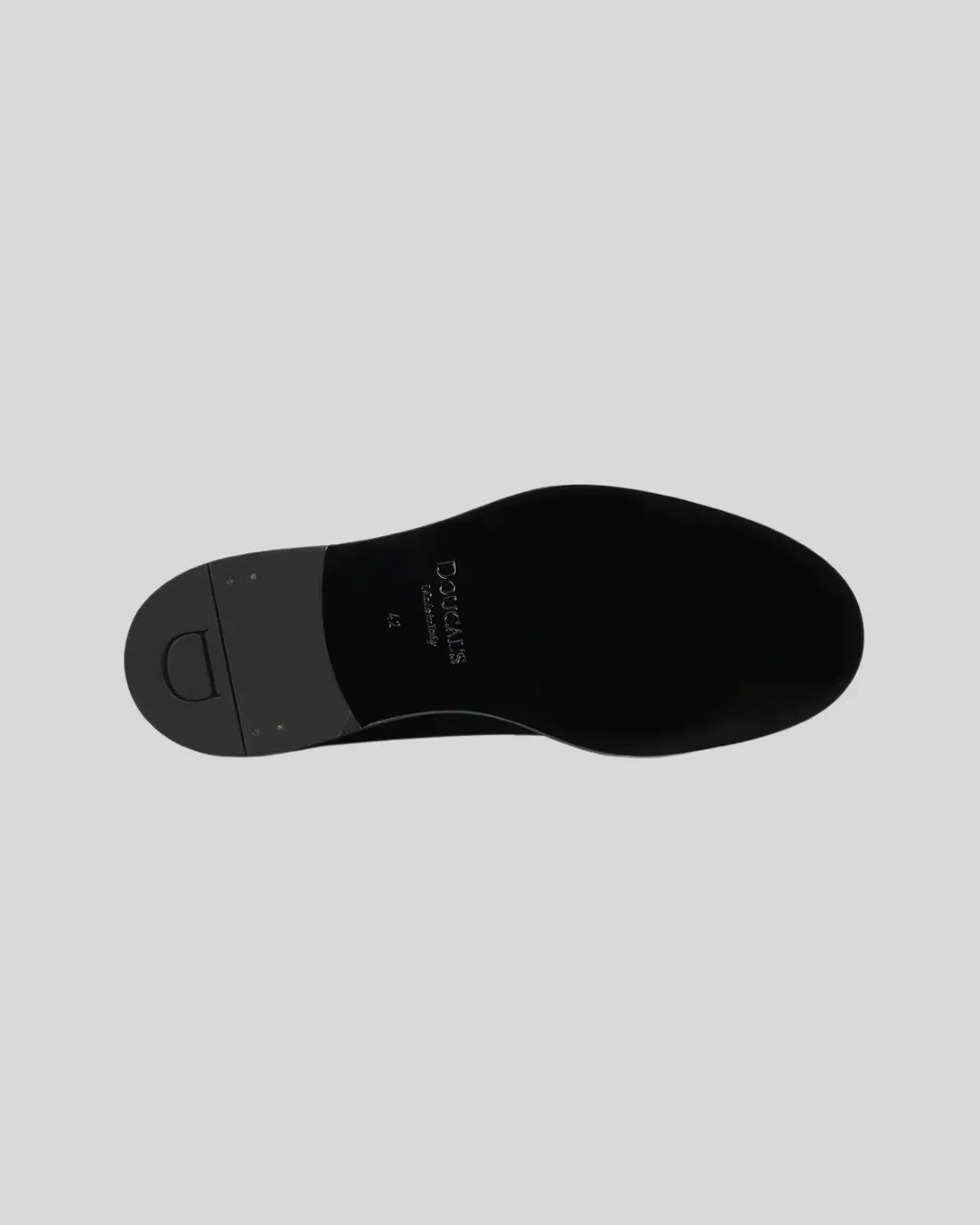 Suola nera in cuoio di scarpa uomo elegante derby su sfondo grigio chiaro.