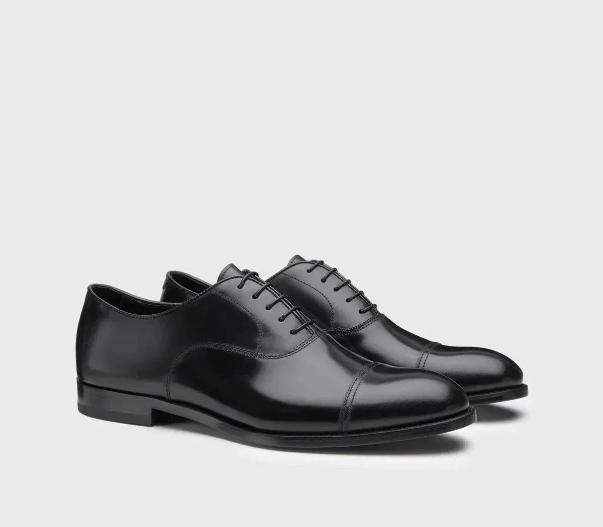 Scarpe eleganti nere Oxford uomo in pelle liscia con punta a coda e lacci, sfondo neutro