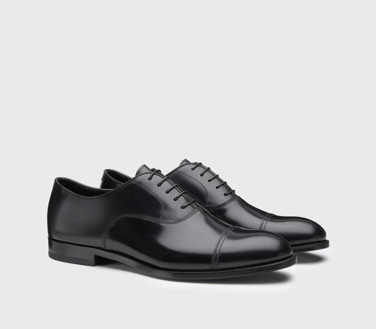 Scarpe eleganti nere Oxford uomo in pelle liscia con punta a coda e lacci, sfondo neutro