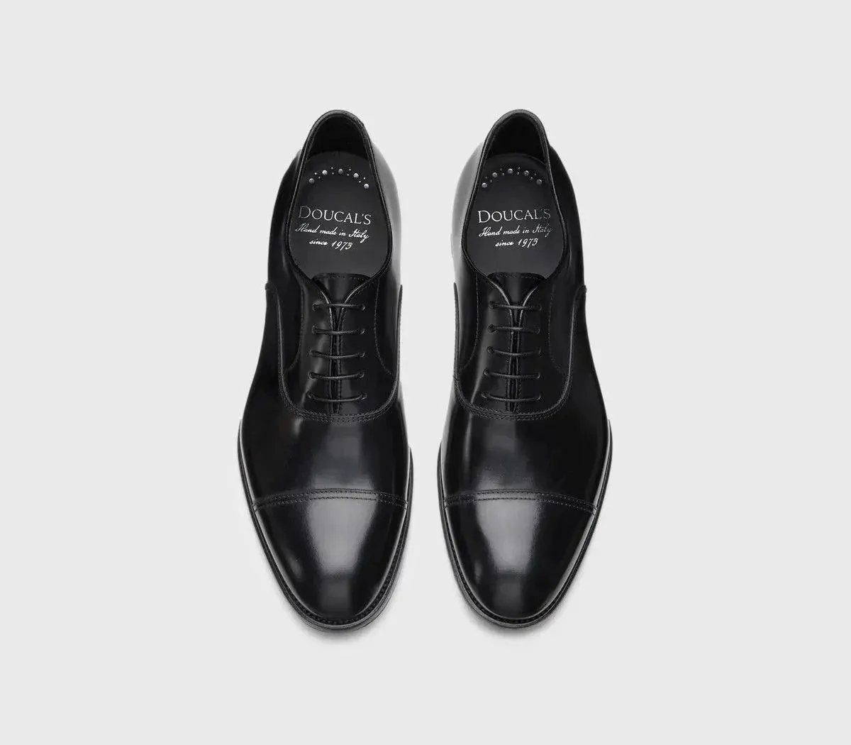 Scarpe Oxford nere da uomo in pelle lucida con punta decorata, stile elegante classico.