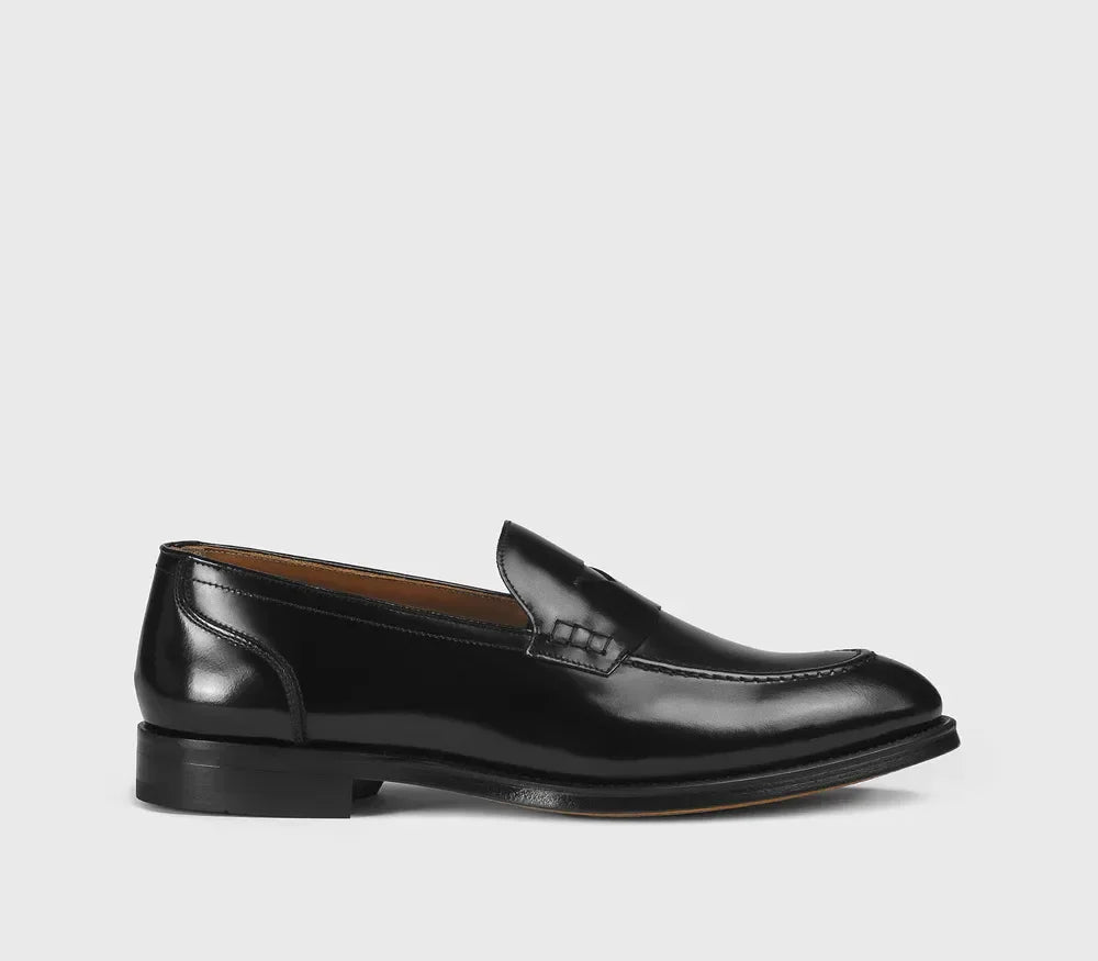 Mocassino penny nero da uomo in pelle lucida, elegante e classico, su sfondo chiaro