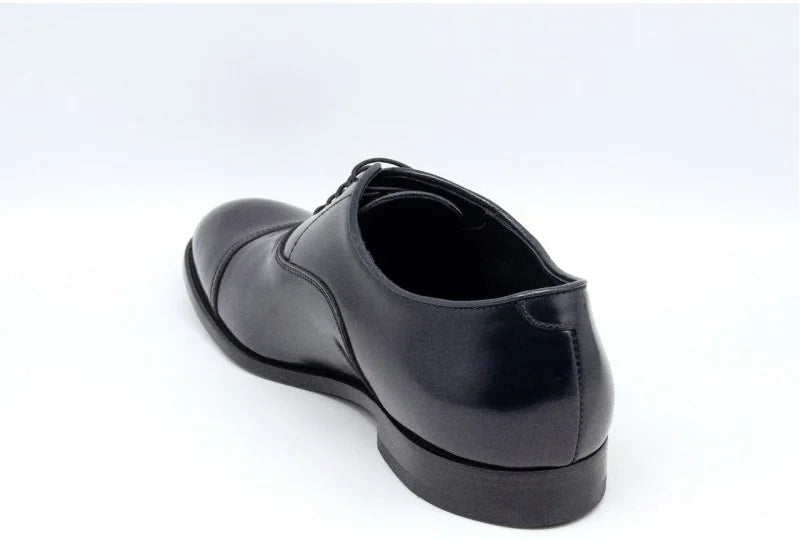 Scarpa stringata uomo in pelle blu elegante su fondo bianco, vista posteriore