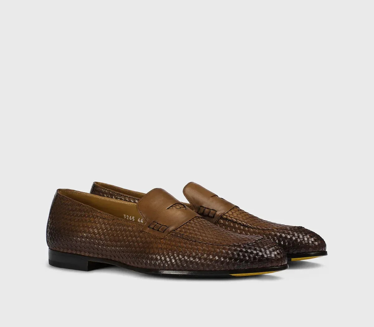 Mocassini uomo intrecciati in pelle marrone scuro, design elegante su sfondo neutro.