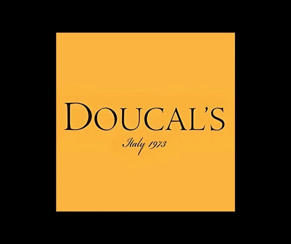 Logo Doucal's su sfondo giallo con scritta 'Italy 1973', marchio calzature uomo eleganti