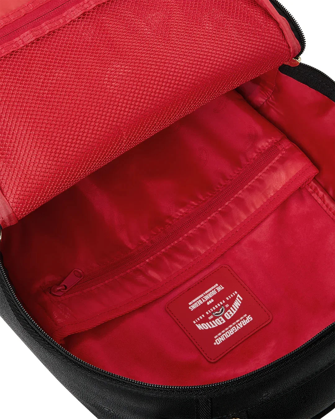 Interno zaino in tessuto rosso con tasca zip e dettagli Limited Edition.
