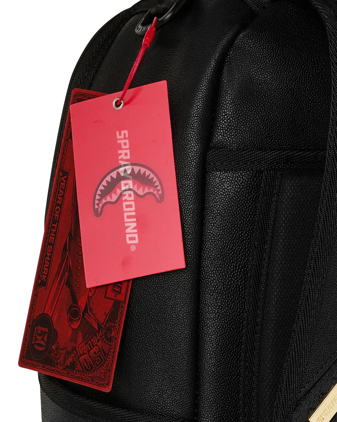 Zaino nero in tessuto con etichetta rossa Sprayground, dettagli moderni e texture grana.