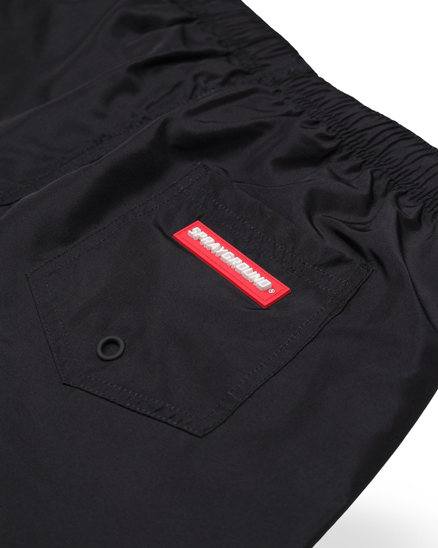 Dettaglio tasca posteriore pantaloncini neri uomo, logo Sprayground rosso visibile