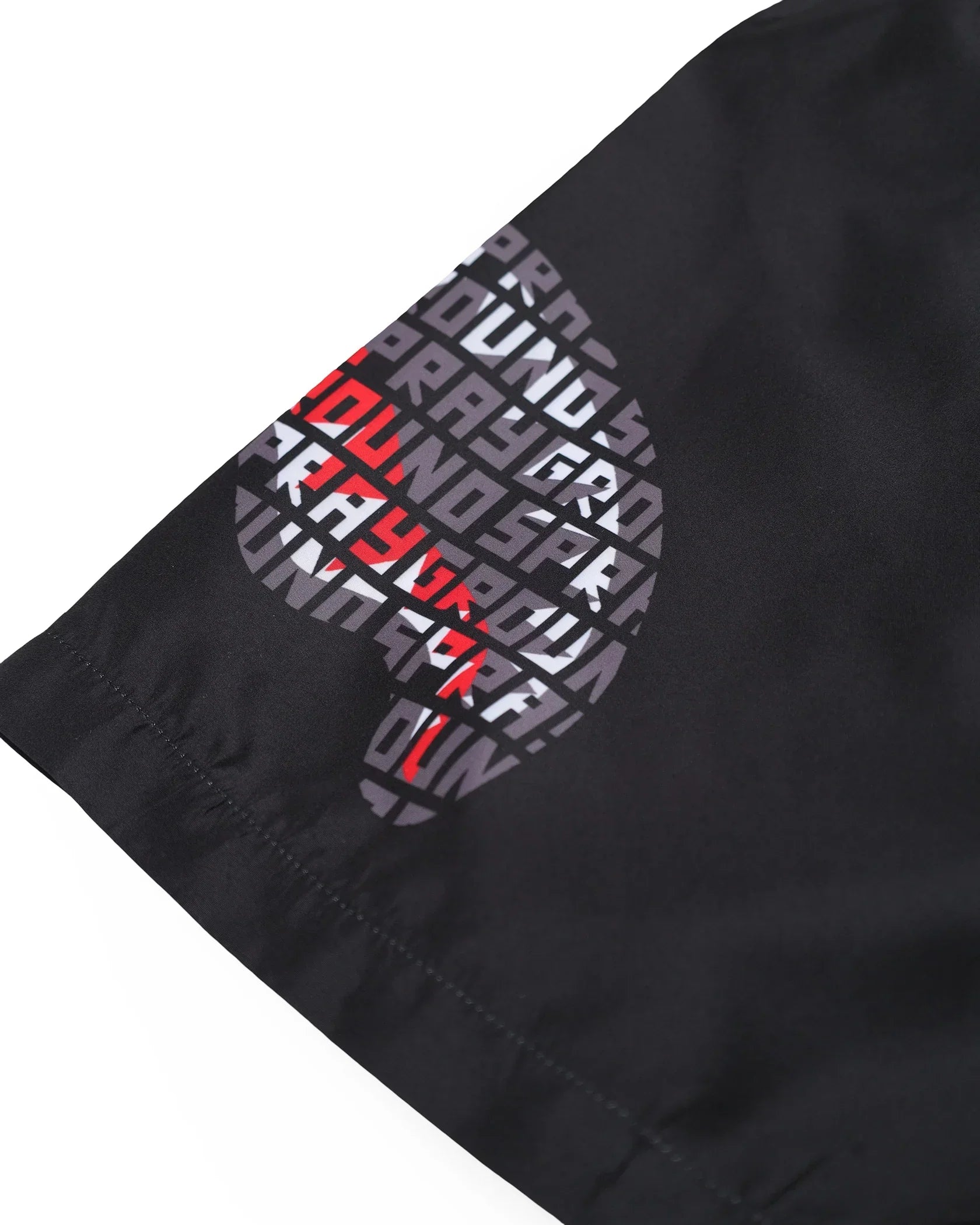 dettaglio tessuto nero con stampa grafica astratta e scritte bianche e rosse, moda uomo