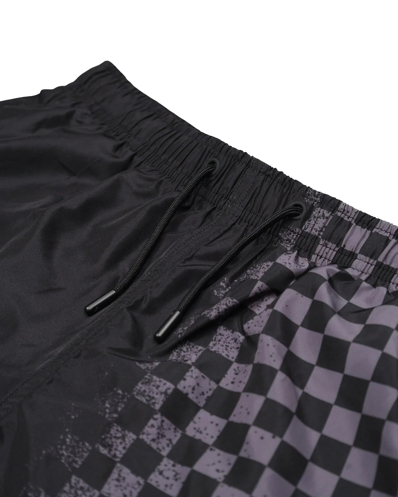 Dettaglio pantaloncini uomo neri con stampa a quadri, vita elasticizzata e laccetti.