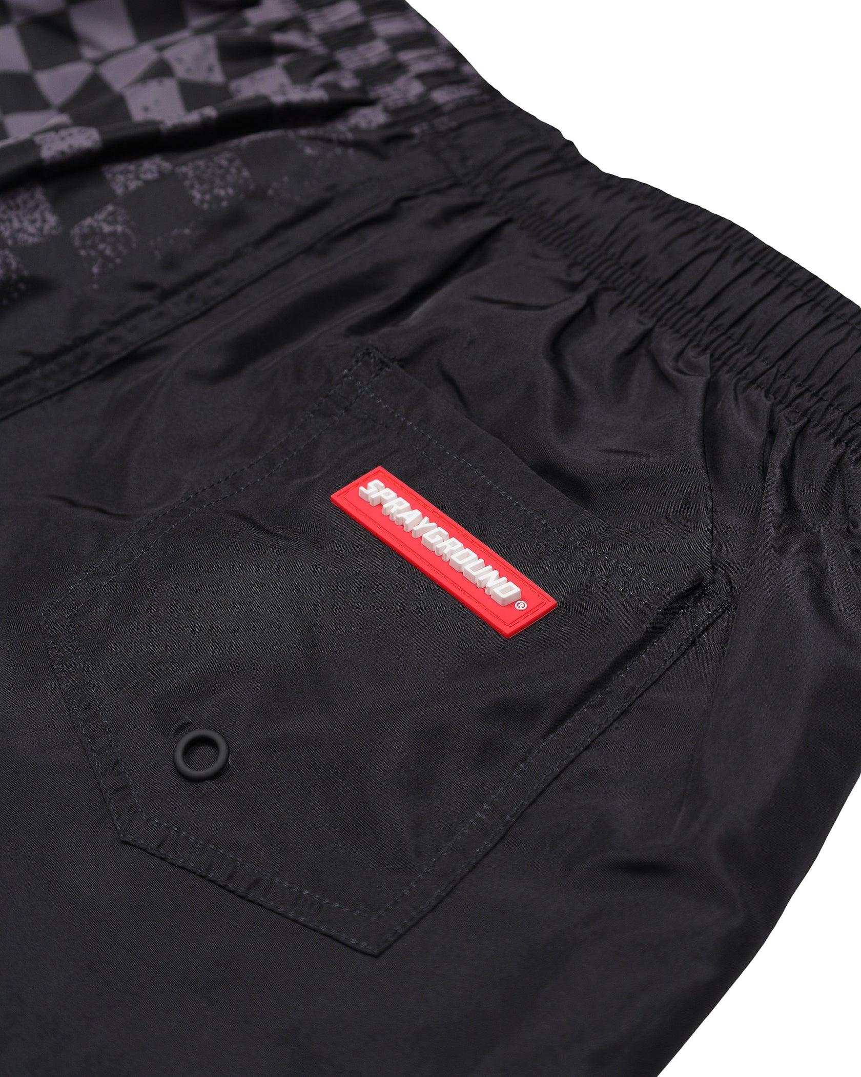 Dettaglio tasca posteriore pantaloncini neri uomo con etichetta rossa Sprayground