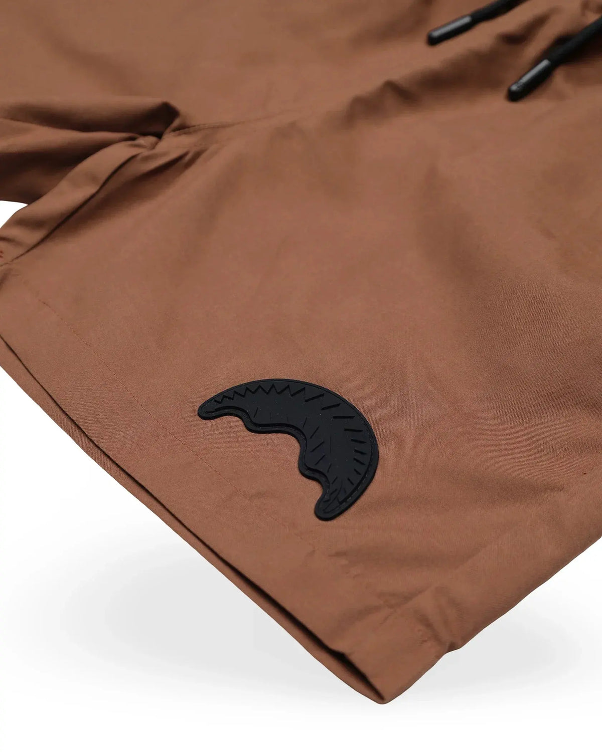 Dettaglio bermuda uomo color terra con logo nero, tessuto liscio e coulisse.