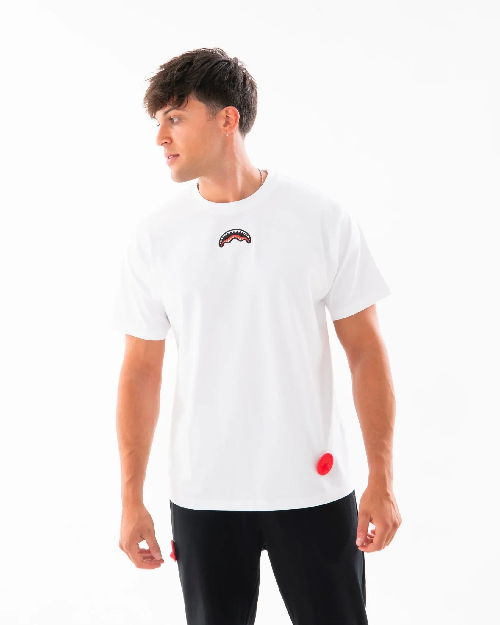 Modello indossa t-shirt bianca da uomo con dettaglio grafico colorato sul petto, look casual.