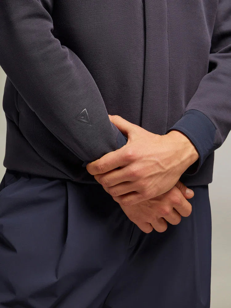 Dettaglio braccia uomo che indossa felpa e pantaloni blu, abbigliamento casual elegante.