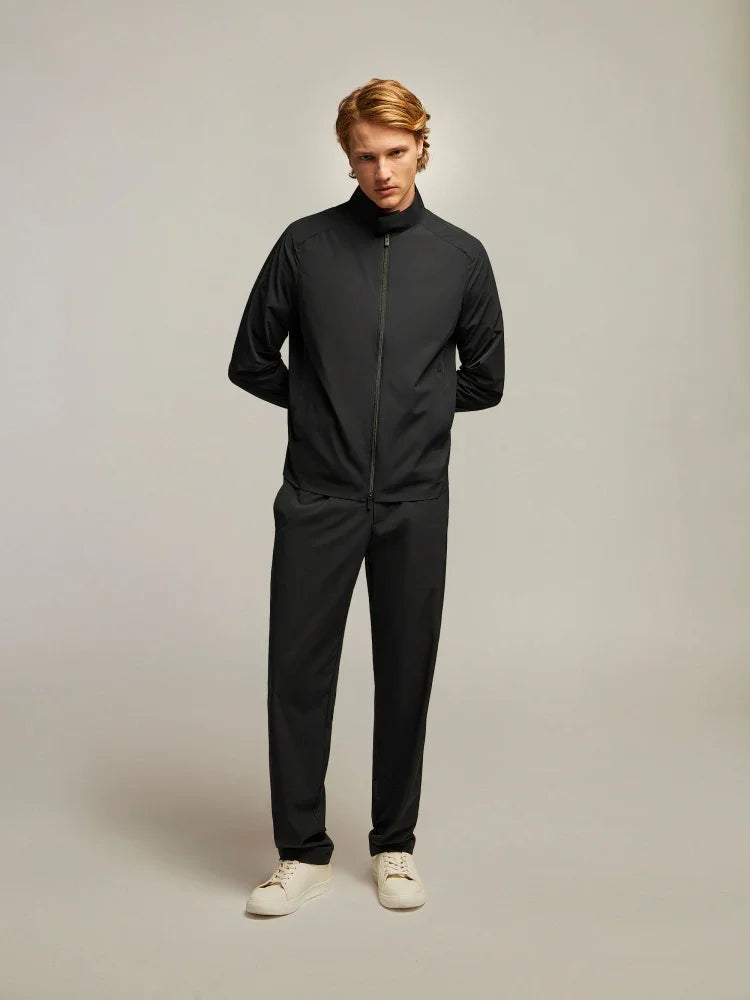 modello uomo con giacca nera e pantaloni abbinati, look minimal elegante, scarpe beige