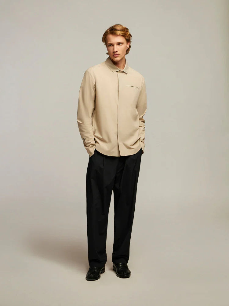 Modello uomo indossa camicia beige elegante e pantaloni neri sartoriali, moda uomo