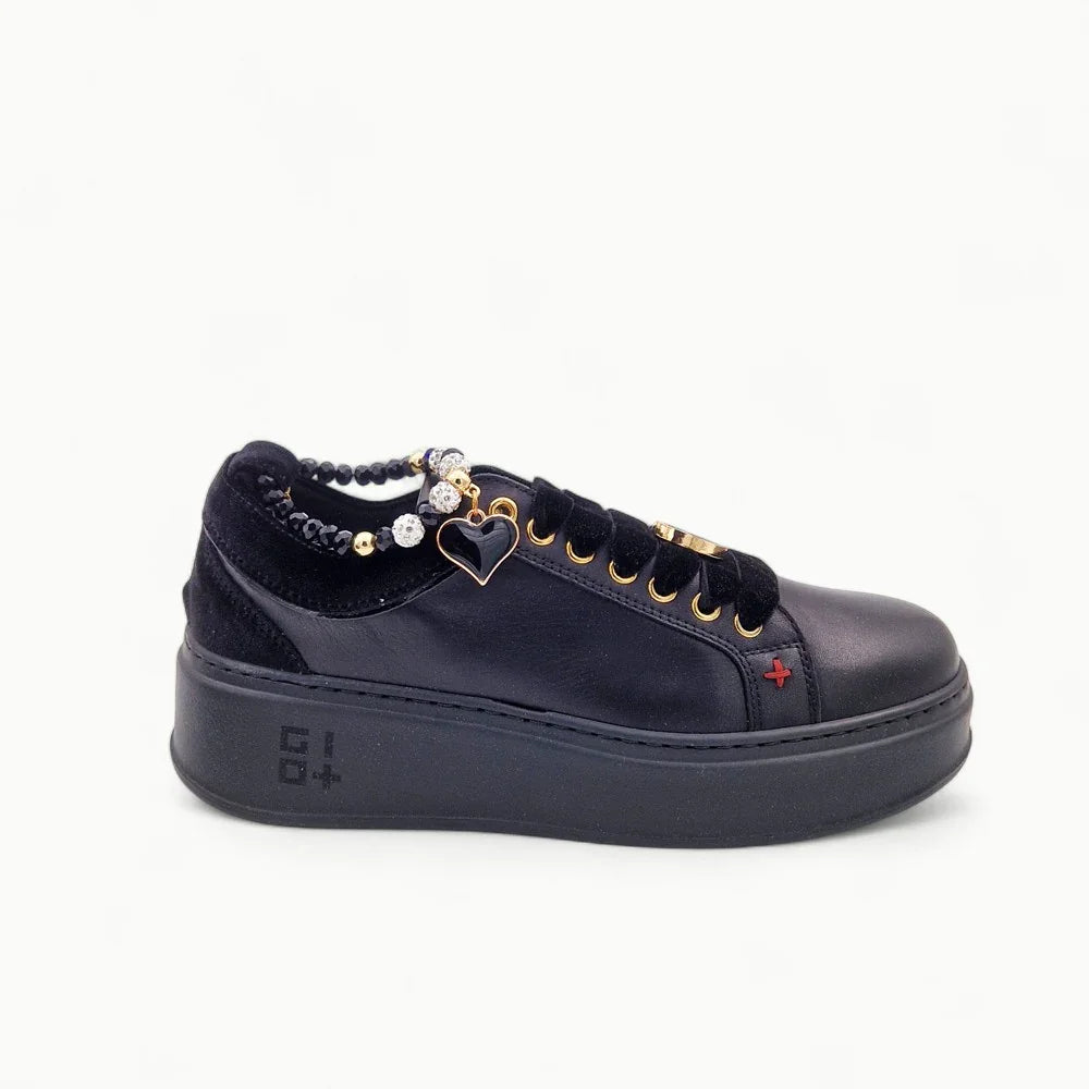 Sneaker donna nera in pelle con platform, dettagli dorati e charm a cuore, stile elegante.