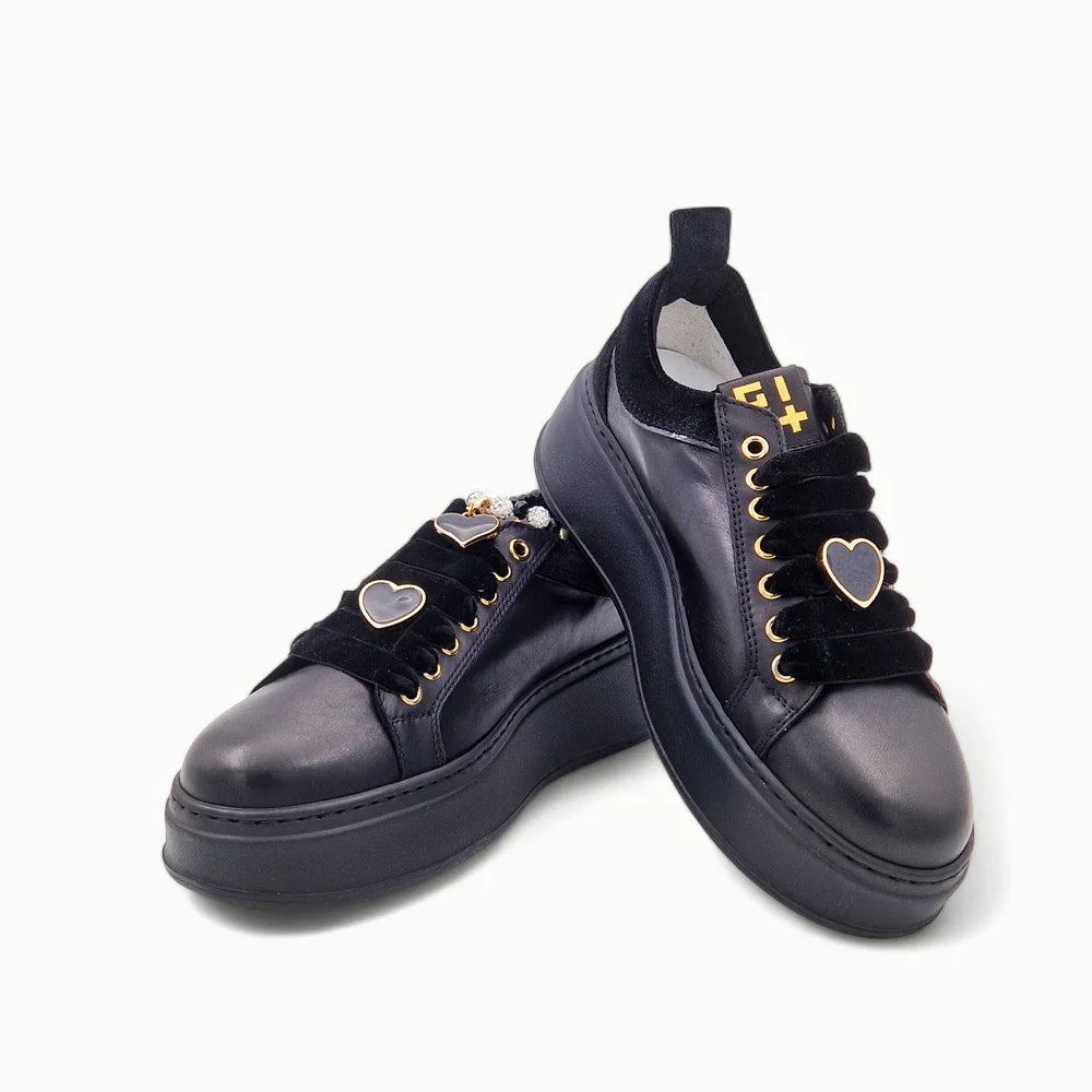 Sneakers nere in pelle con dettagli oro e cuore sulle stringhe, moda donna elegante.