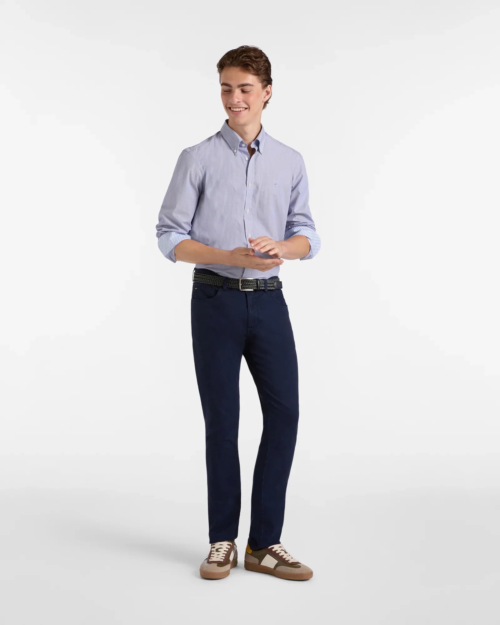 Modello indossa camicia celeste uomo con dettagli a contrasto e pantaloni blu navy eleganti.