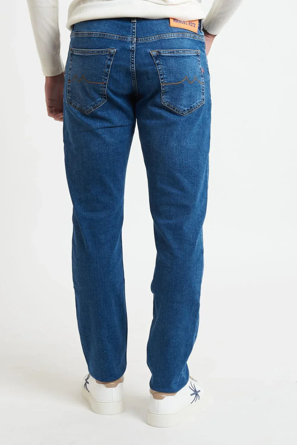 Jeans uomo denim chiaro a cinque tasche, vestibilità regular, visti da dietro su sfondo bianco.