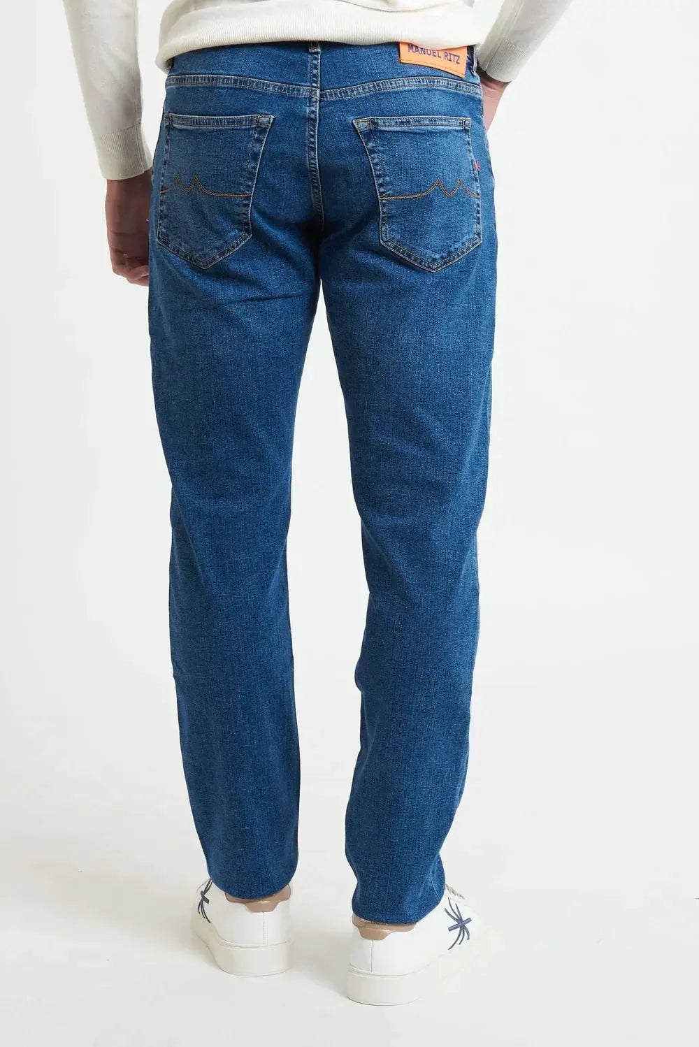 Jeans uomo denim chiaro a cinque tasche, vestibilità regular, visti da dietro su sfondo bianco.