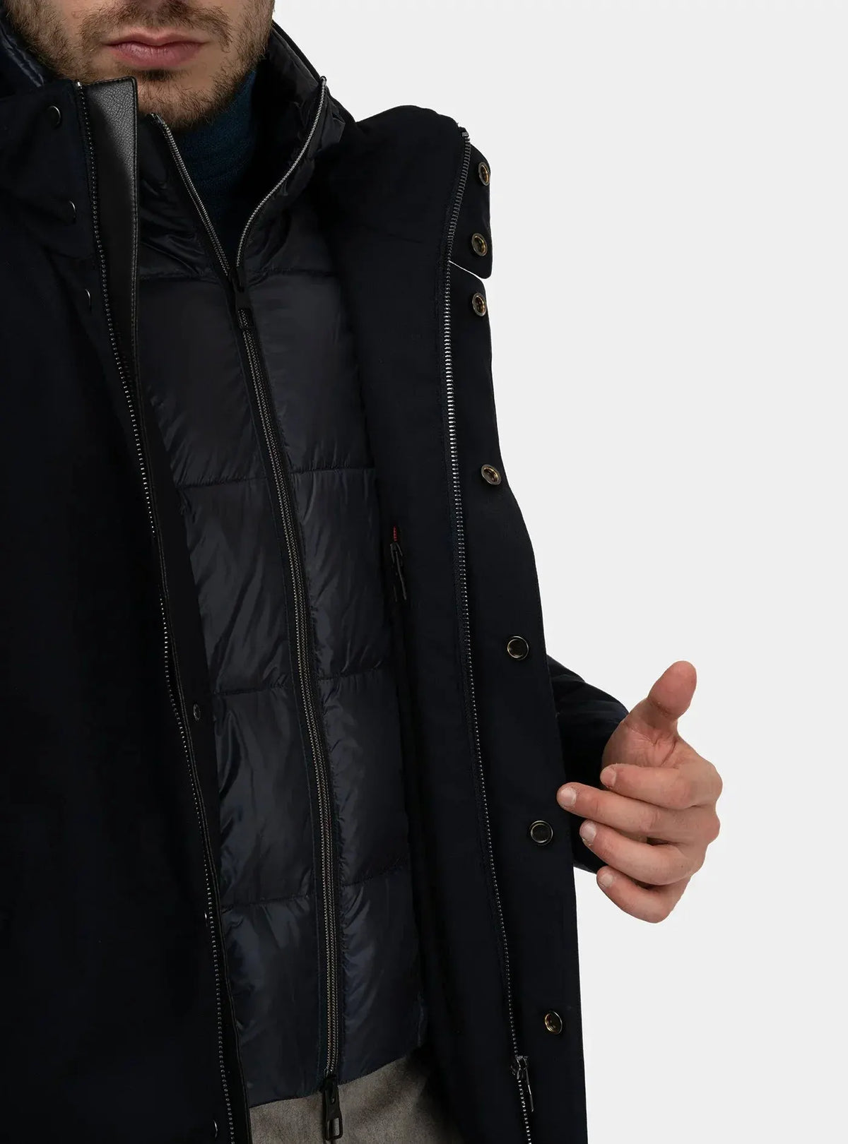 Dettaglio uomo con trench blu e giubbotto imbottito, abbigliamento elegante uomo