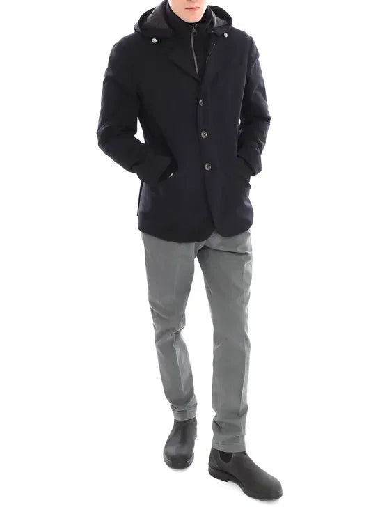 Giacca invernale uomo blu con cappuccio, pantaloni grigi e stivaletti neri