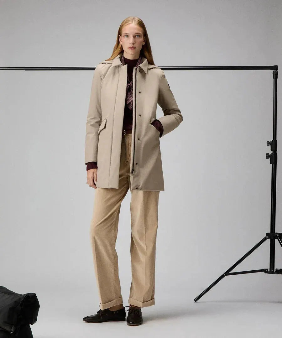 Modella con trench beige slim fit, pantaloni chiari e maglione bordeaux, look elegante donna.