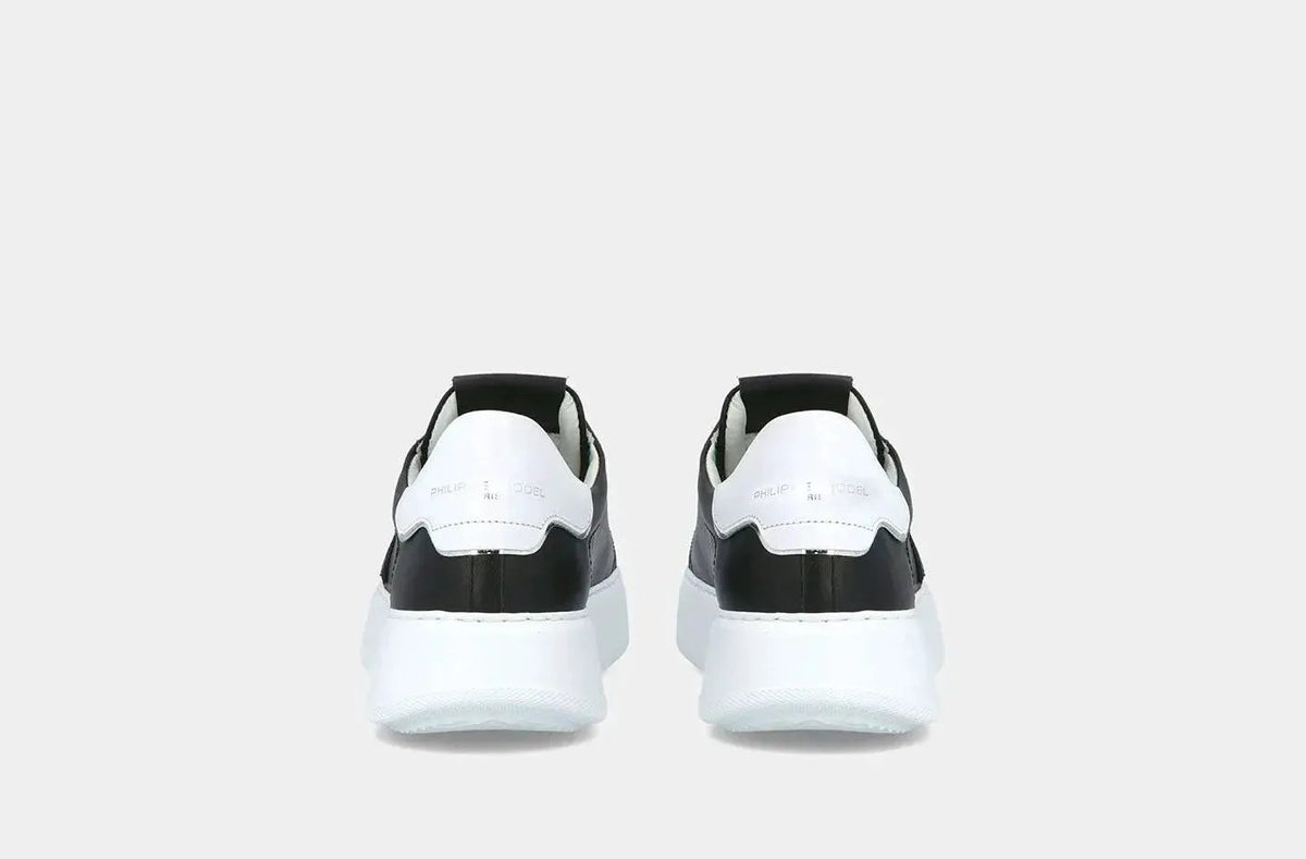 Sneakers uomo nere e bianche con suola spessa, vista posteriore, stile moderno