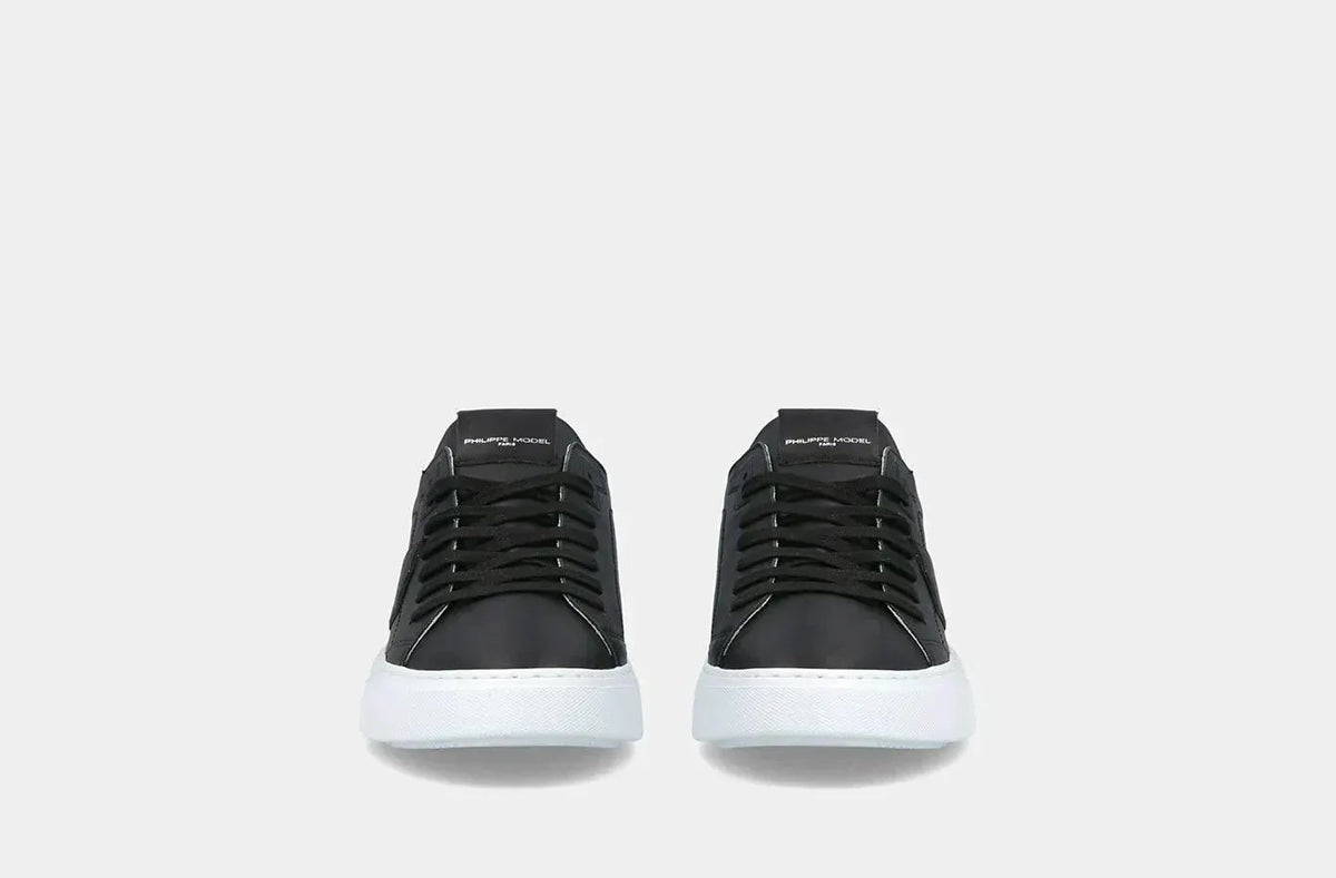 Sneakers uomo nere con suola bianca, lacci neri e logo visibile sulla linguetta