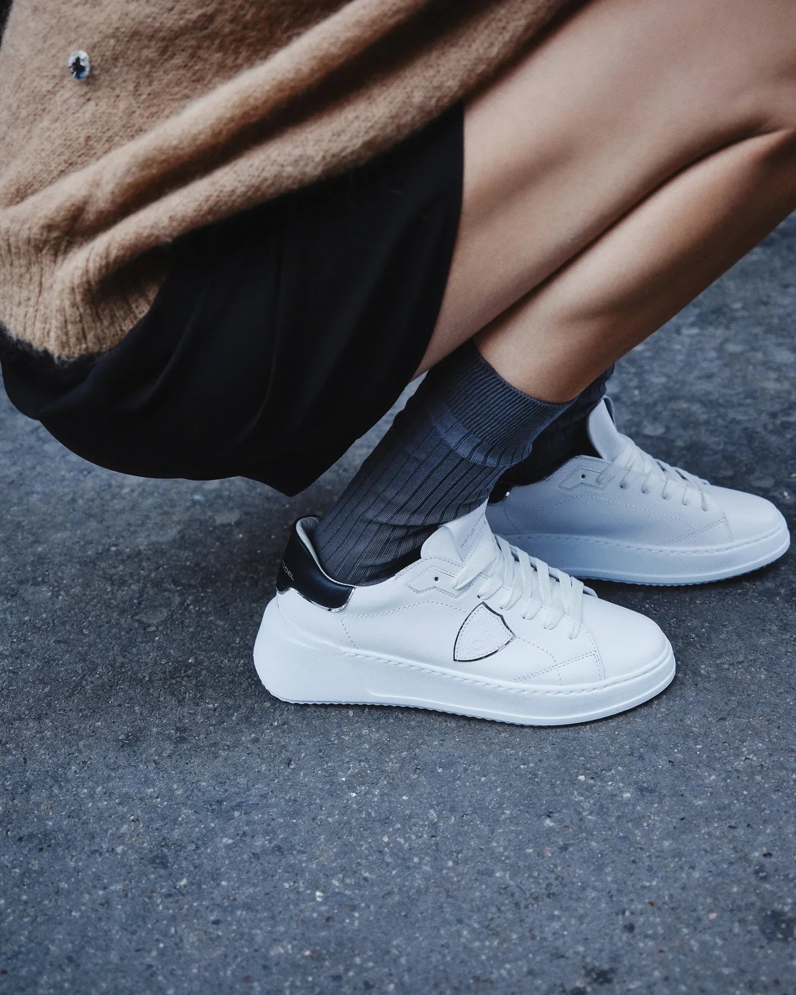 Sneakers donna bianche con dettagli neri indossate, look urbano casual