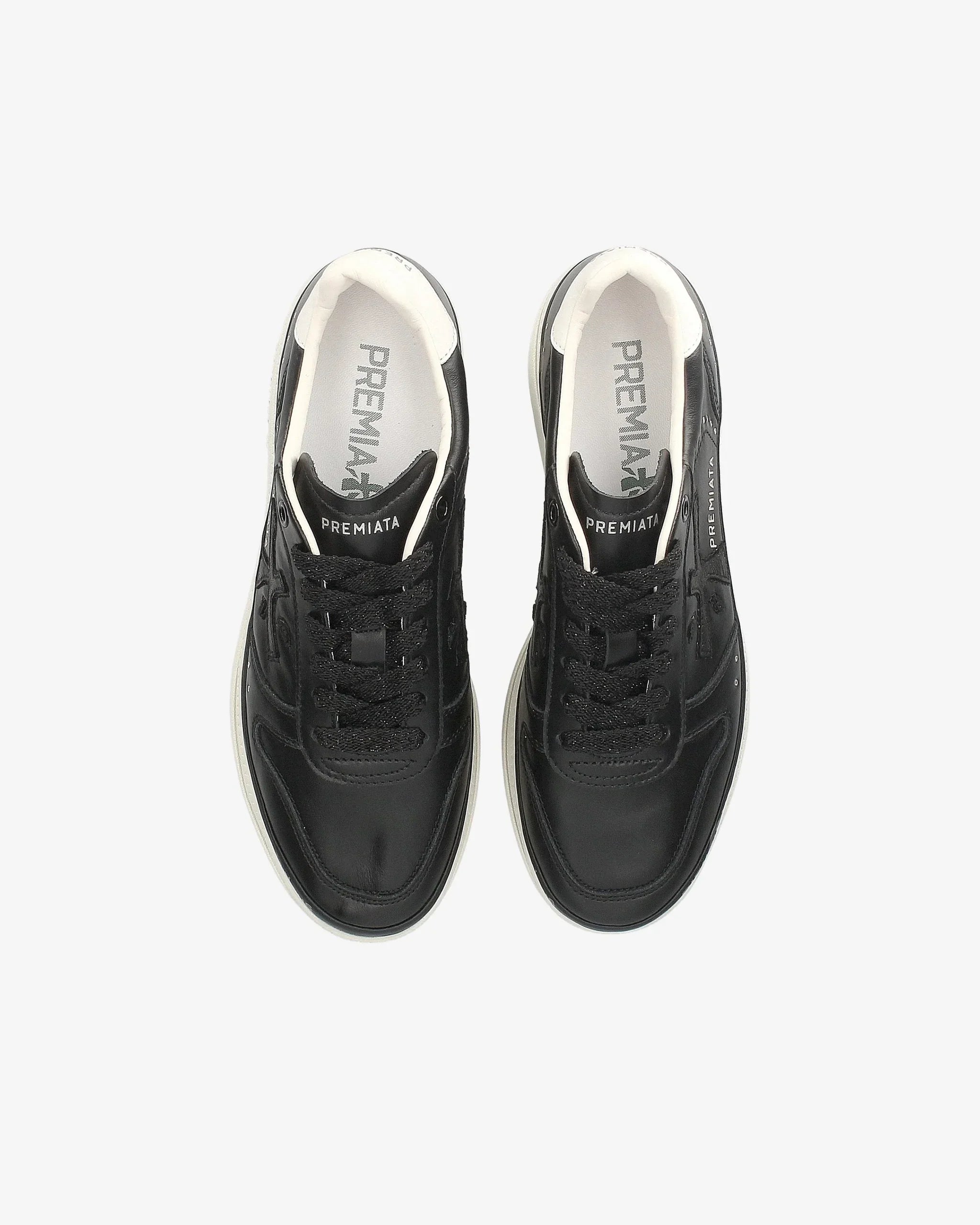 Sneakers nere da donna con lacci, design urbano, fondo bianco, vista dall'alto