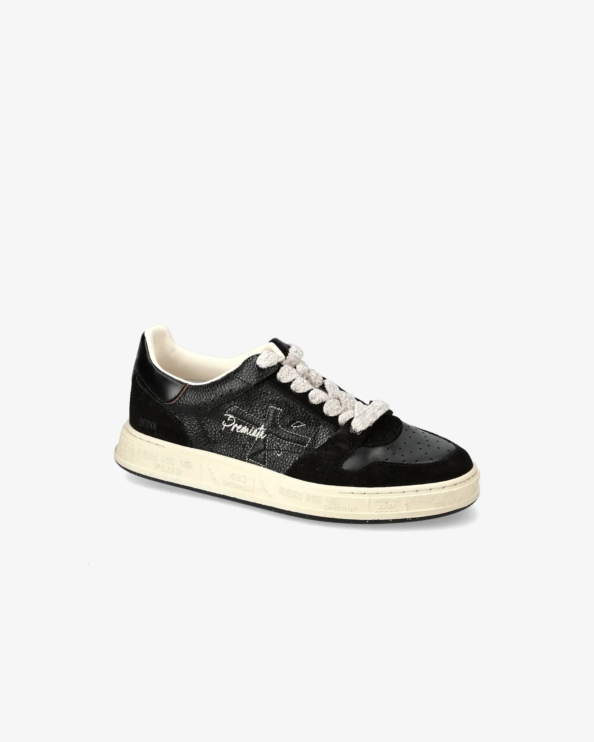 Sneaker nera da donna con lacci bianchi, pelle effetto lucido e suola beige chiaro.