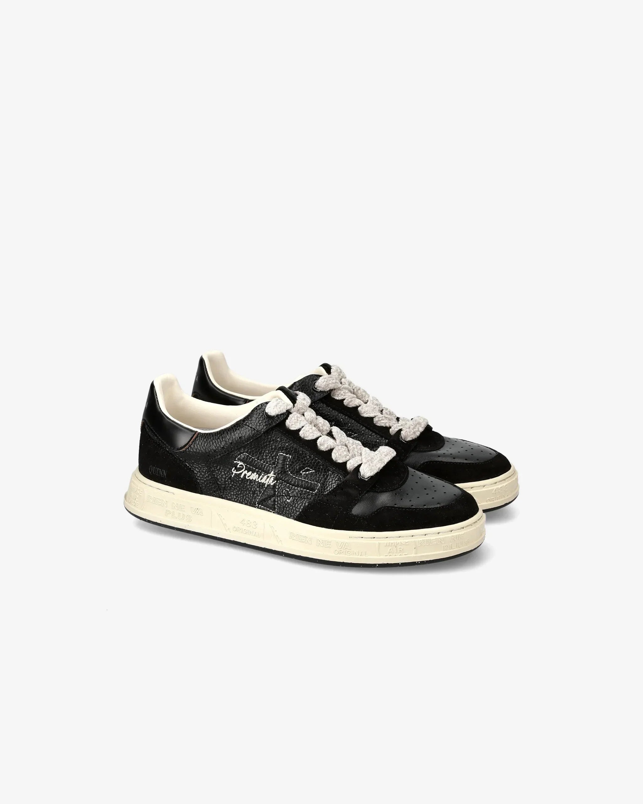 Sneaker nera da donna in pelle e tessuto con suola chiara e lacci bianchi, stile casual.