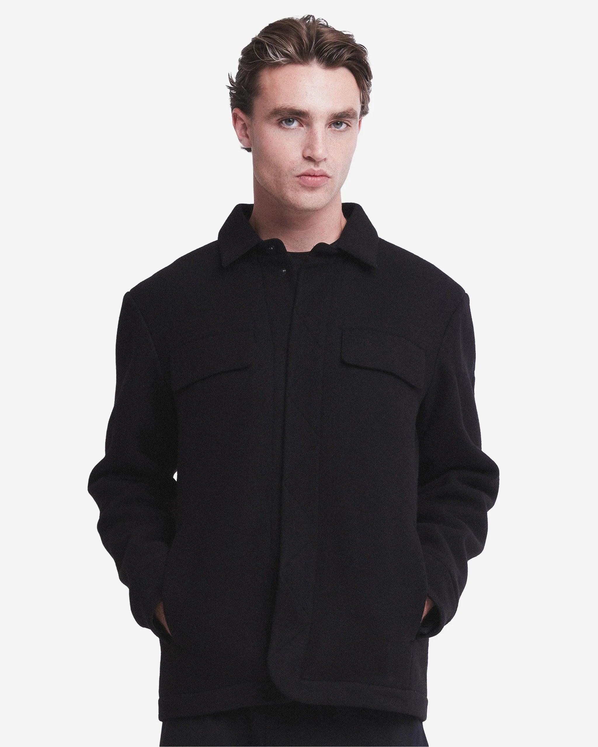 Giacca uomo nera elegante con tasche sul petto, stile casual, fondo chiaro.