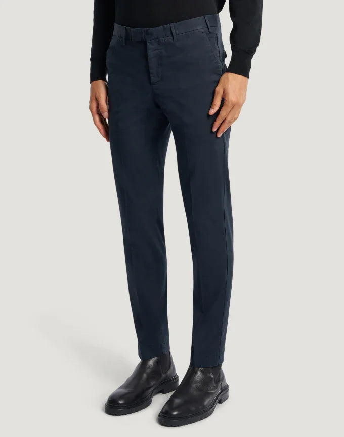 Pantaloni uomo blu navy eleganti, vestibilità slim, indossati con maglione nero e stivaletti