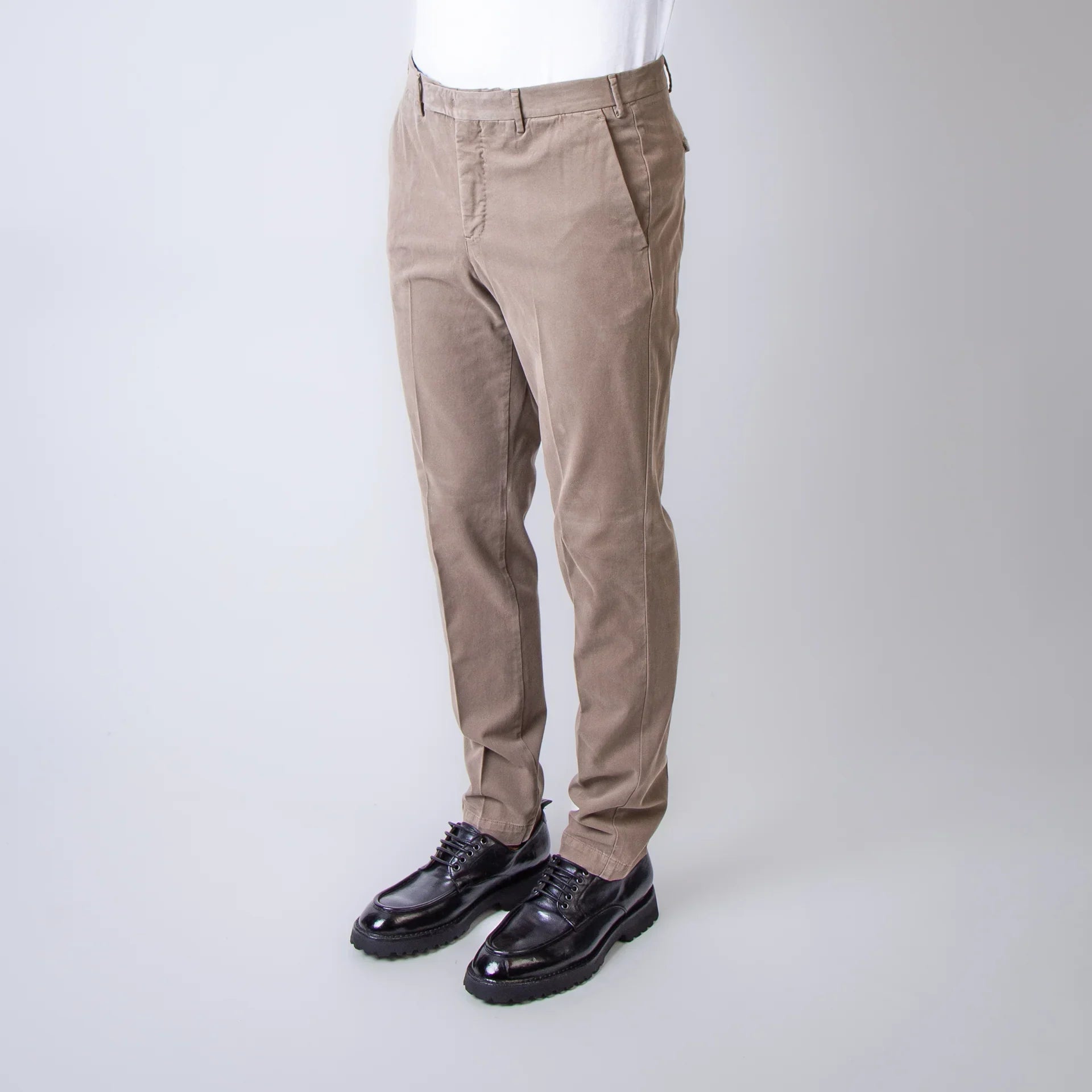 Pantaloni uomo beige eleganti, fit moderno, indossati con camicia bianca e scarpe nere