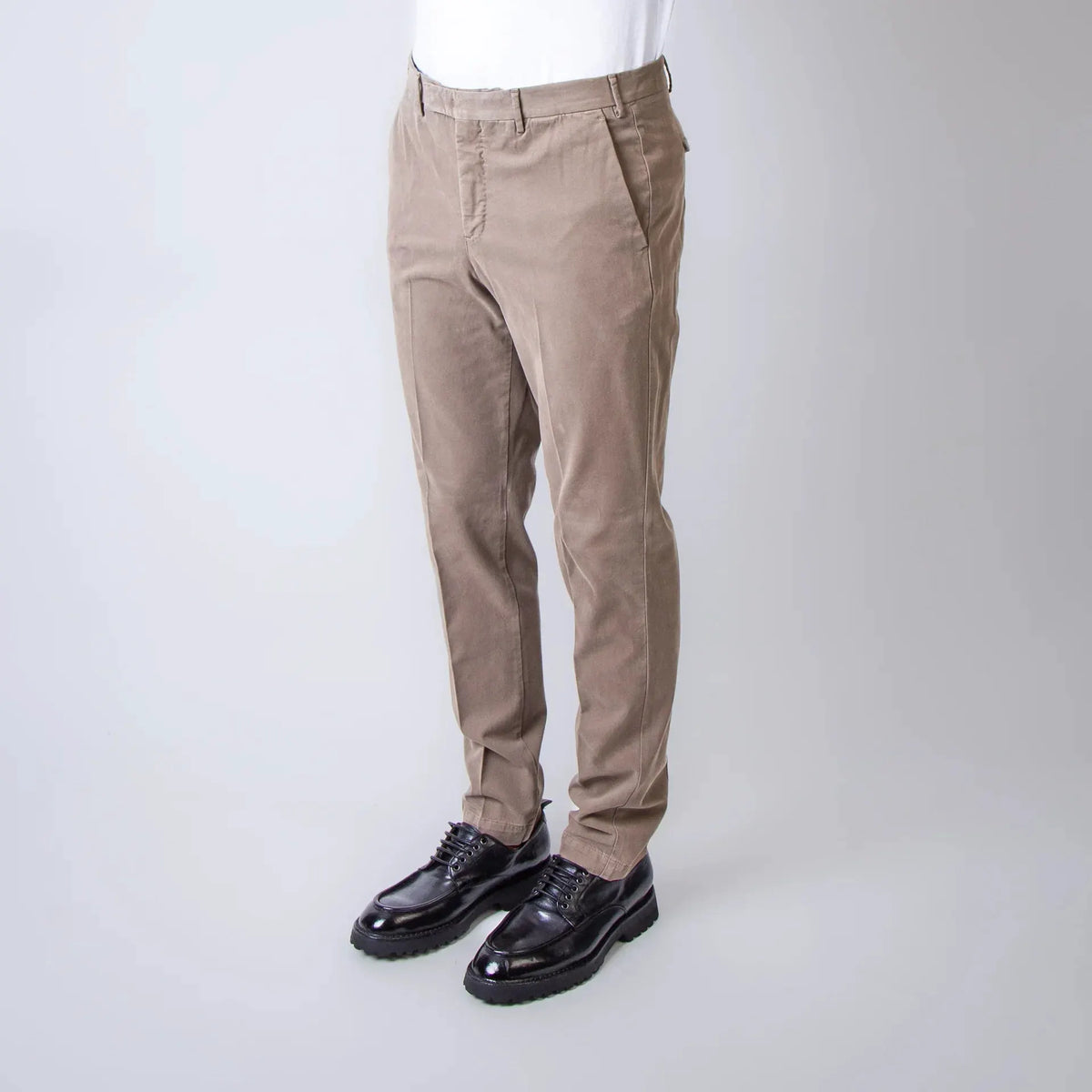 Pantaloni uomo beige eleganti, fit moderno, indossati con camicia bianca e scarpe nere