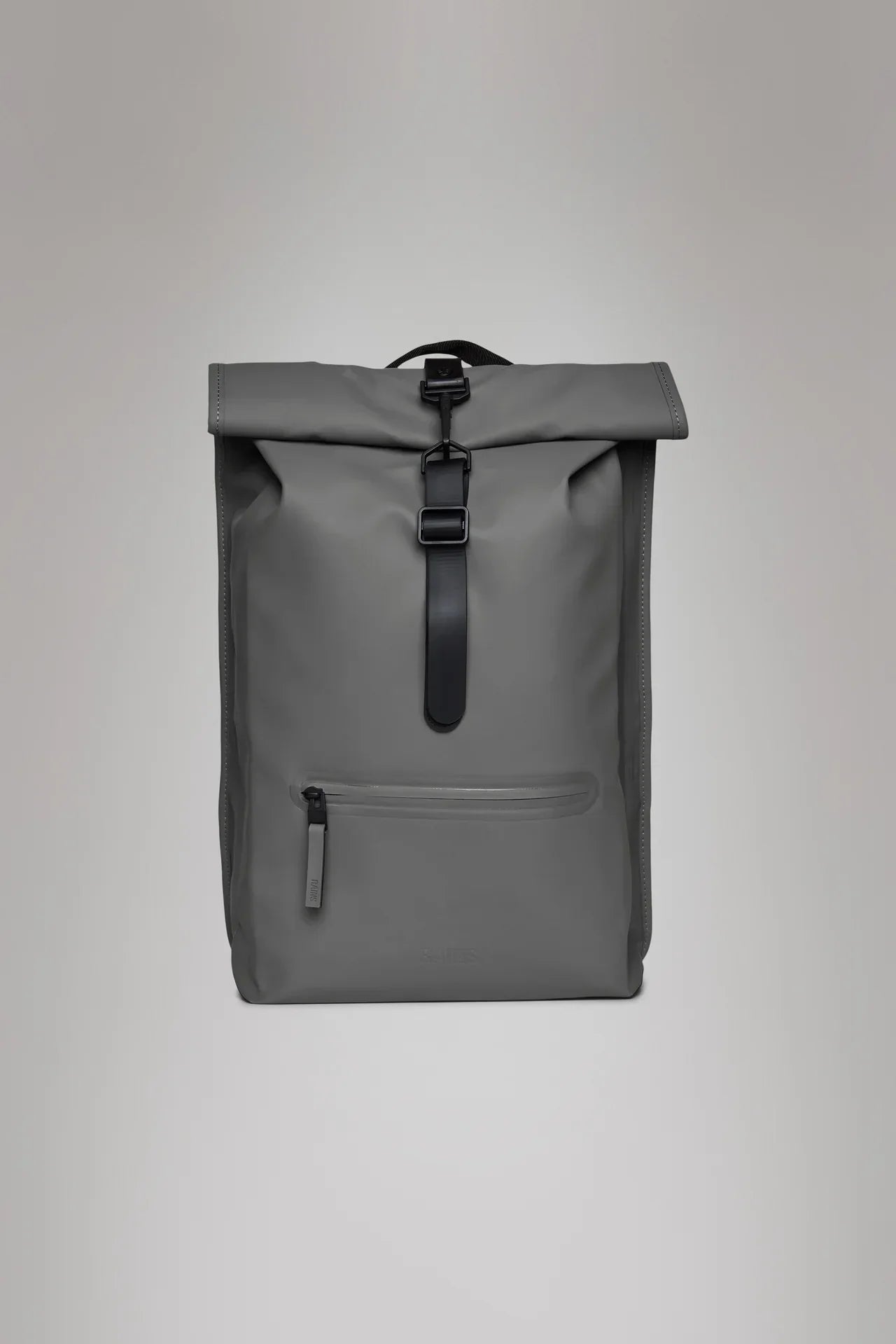 Zaino grigio impermeabile con chiusura roll-top e tasca frontale, sfondo neutro.