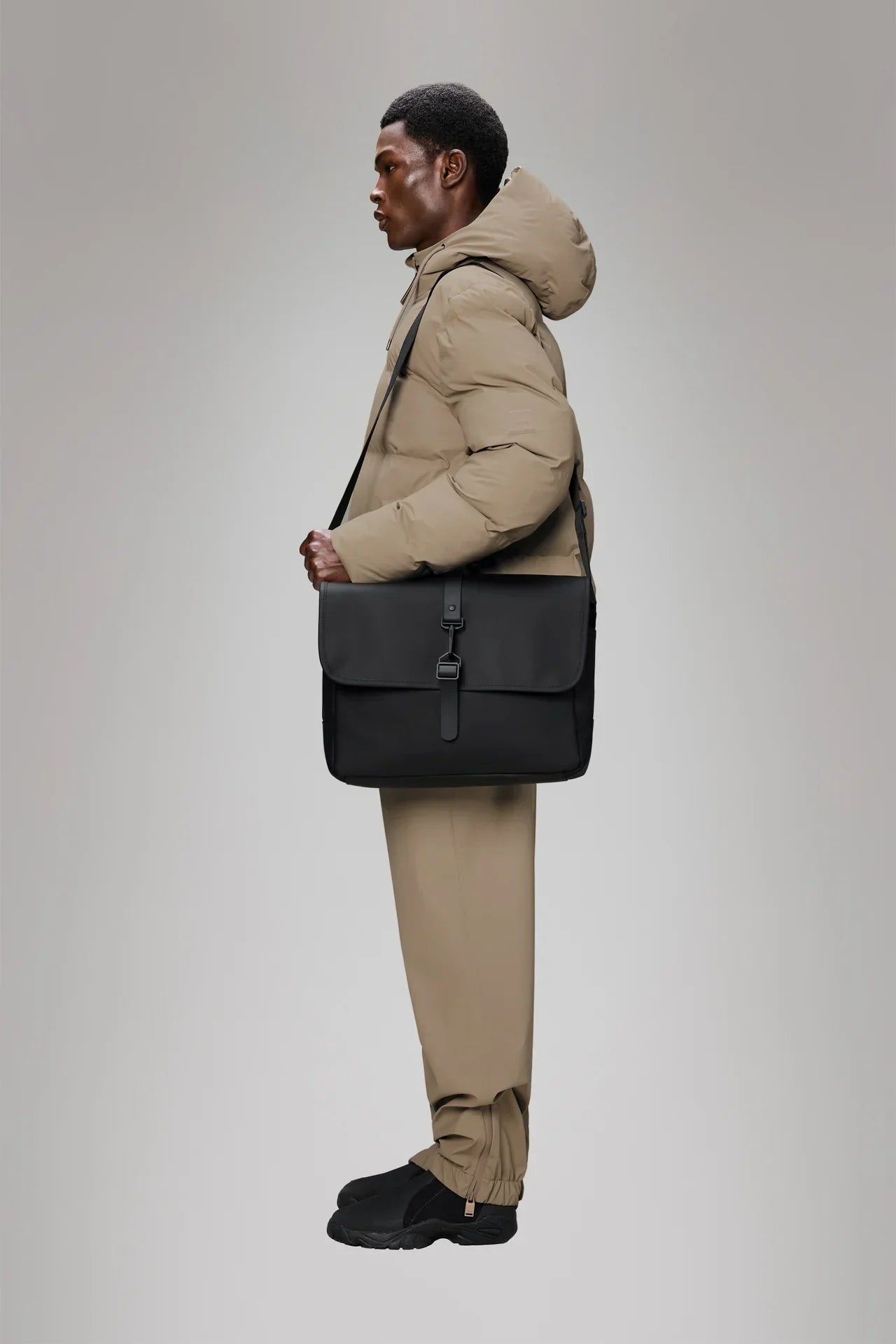Modello con giacca beige indossa borsa tracolla nera elegante, stile casual moderno