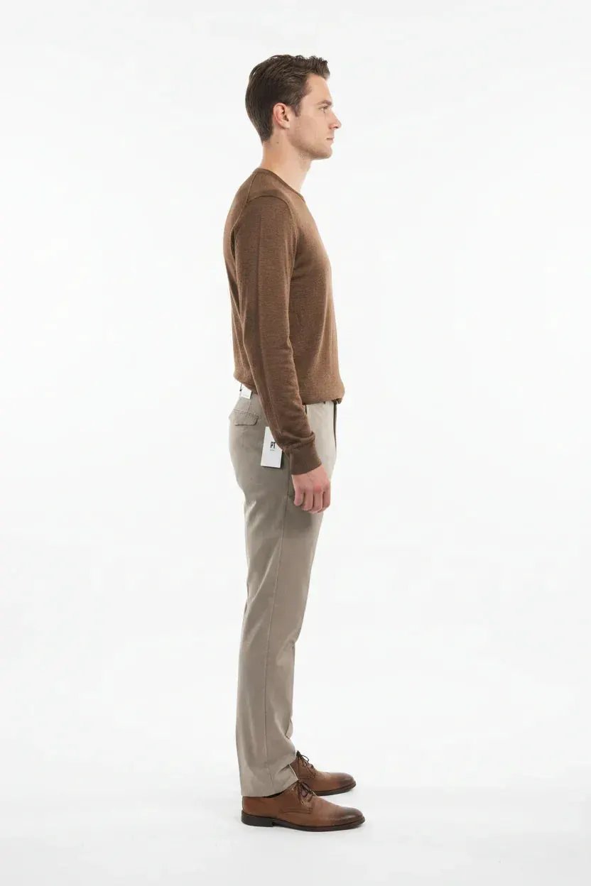 Uomo in maglione marrone e pantaloni beige eleganti, scarpe in pelle, moda uomo