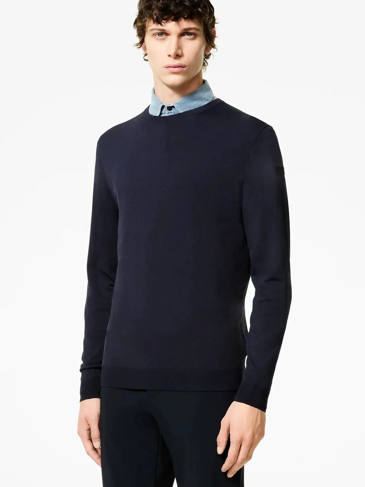 Maglione uomo blu scuro in lana merino, vestibilità slim, abbinato a camicia azzurra.