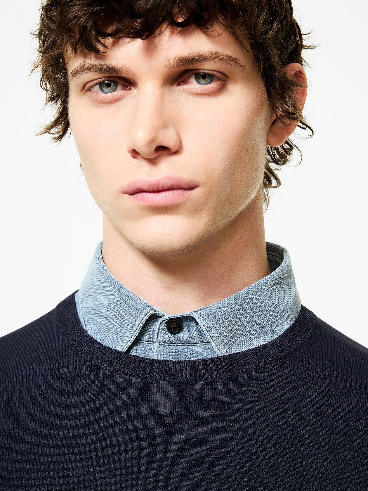 Maglione uomo blu girocollo in lana merino con camicia azzurra, moda elegante.