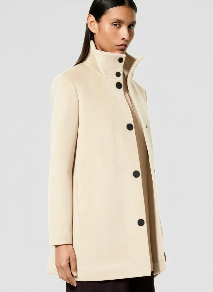 Cappotto donna beige elegante con bottoni neri, design minimal e collo alto.