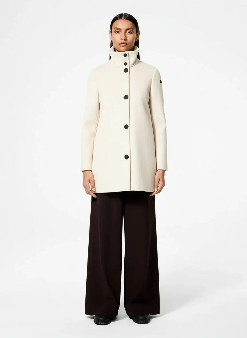 Cappotto donna crema elegante con bottoni neri, colletto alto, stile moderno su sfondo bianco