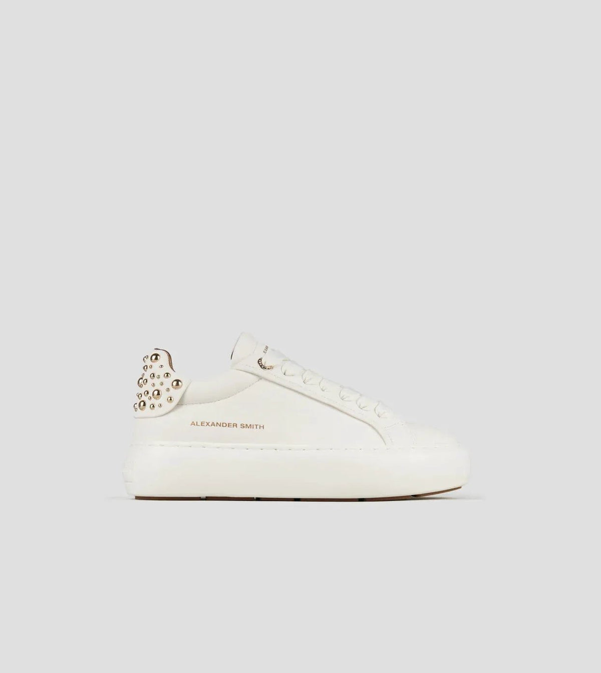 Sneaker donna in pelle bianca con borchie dorate sul tallone, design moderno