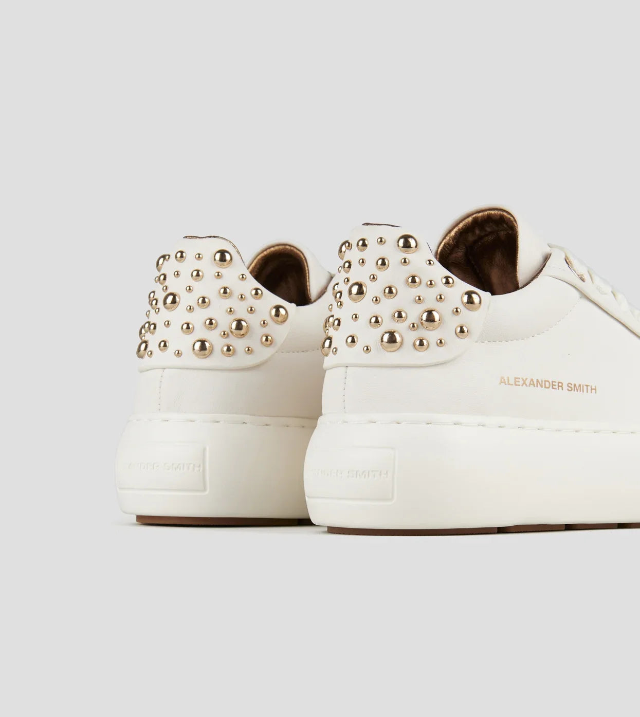 Sneakers donna bianche in pelle con borchie dorate sul tallone, modello Alexander Smith