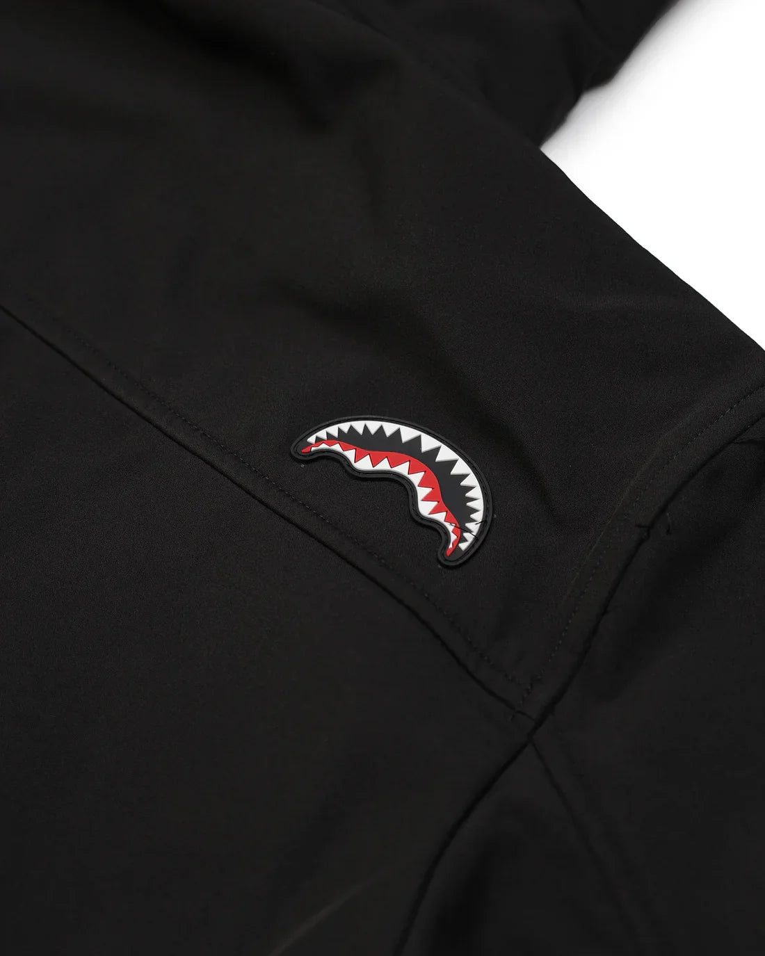 Giacca softshell nera da uomo con logo a forma di bocca di squalo sul braccio